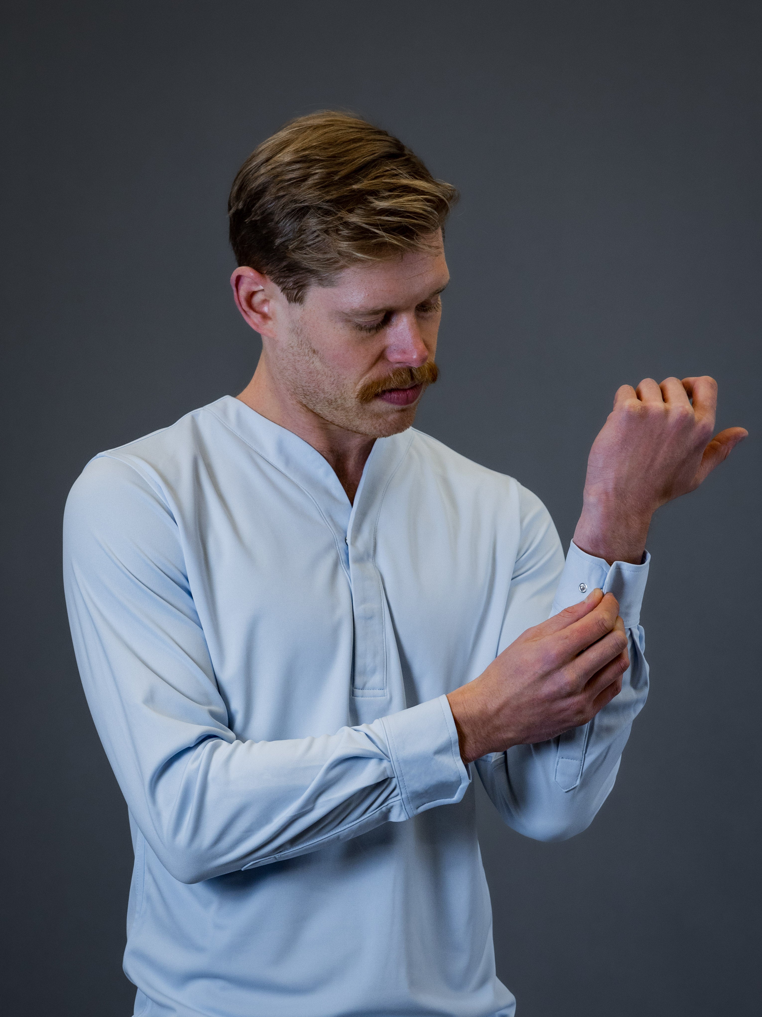 male model showing a light blue collarless dress shirt made by Cheegs Apparel
