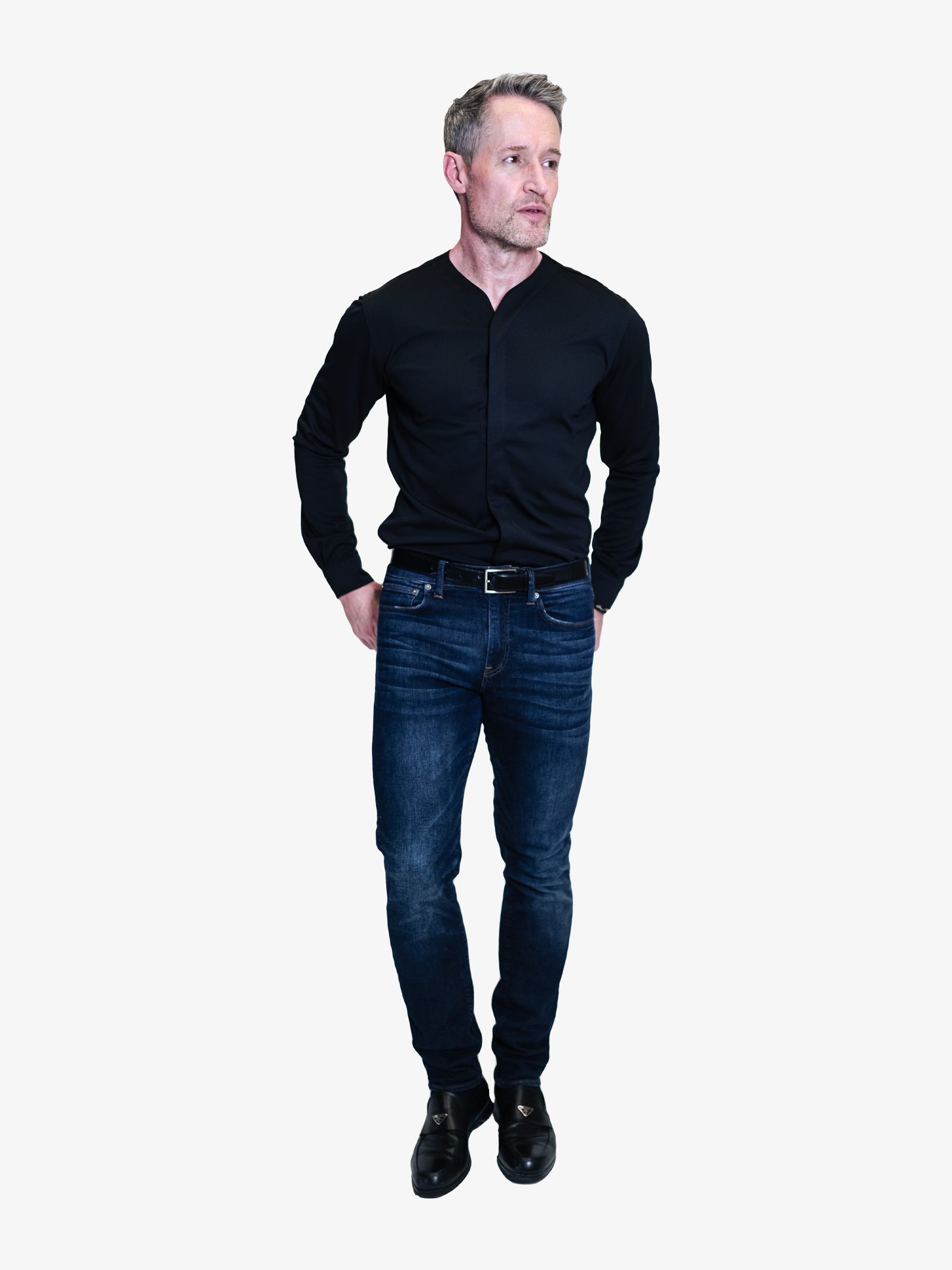 Man wearing a collarless long sleeve dress shirt tucked into a pair of blue jeans