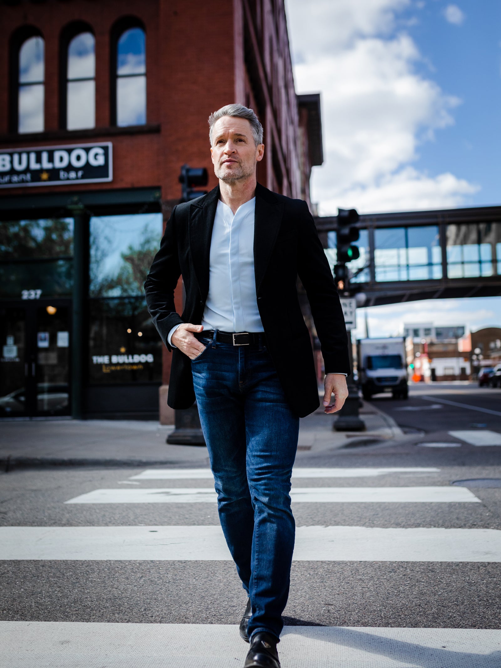 business man wearing mens casual dress shirt with a dark sports coat and dark blue jeans