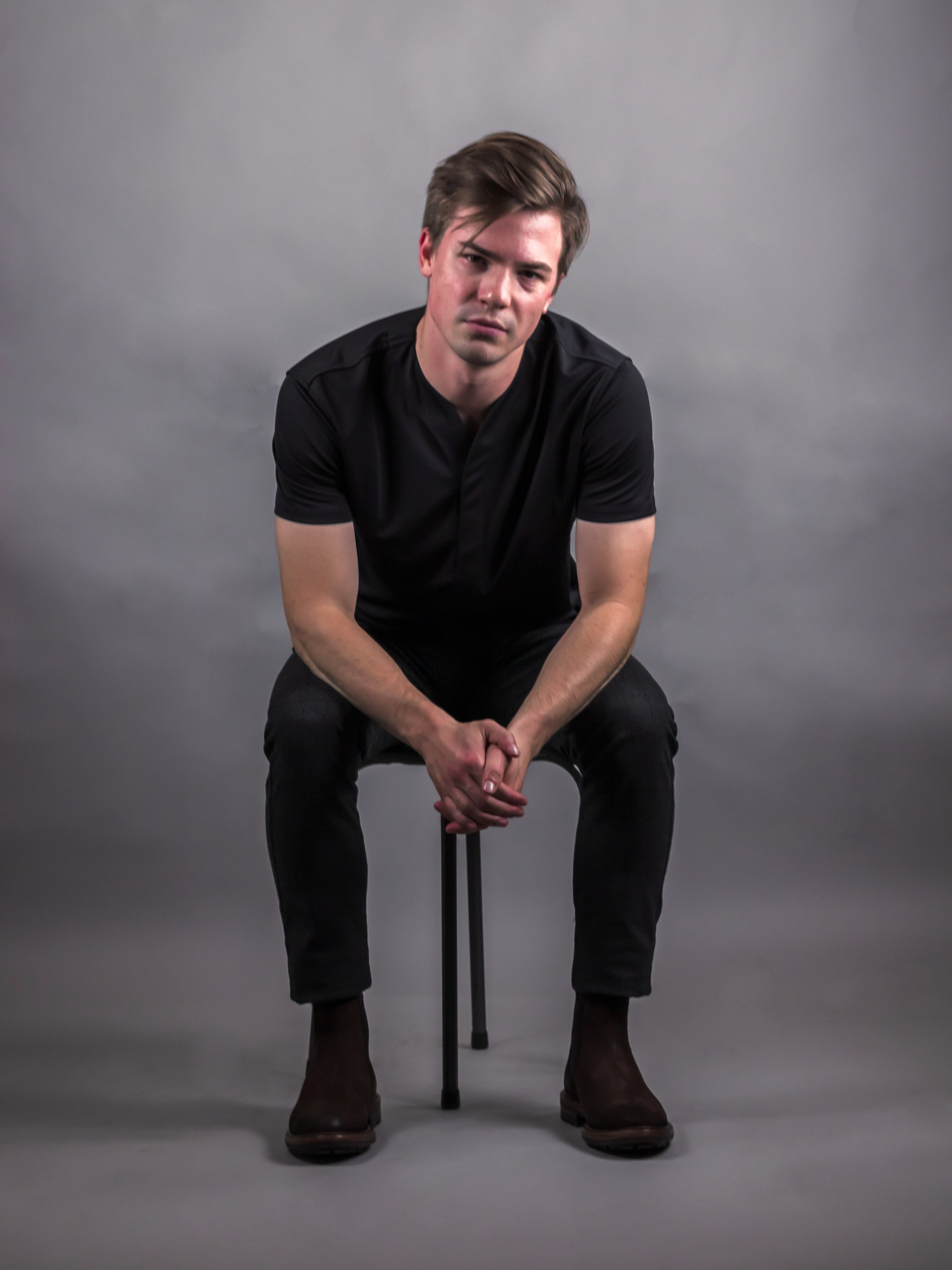 Model wearing mens collarless short sleeve shirt in the color black made by Cheegs