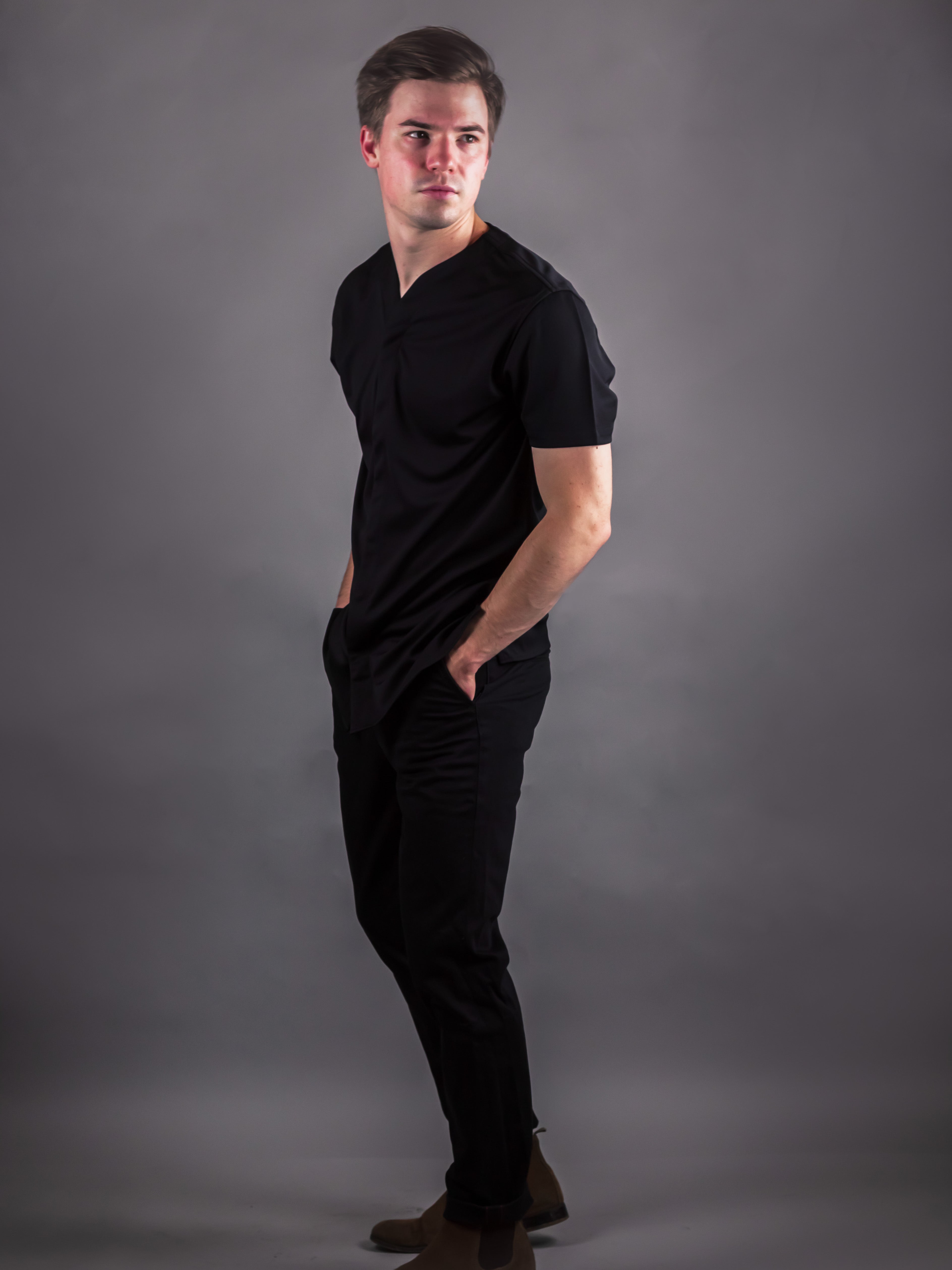 man showing the side of a Cheegs collarless golf shirt for men in the color black