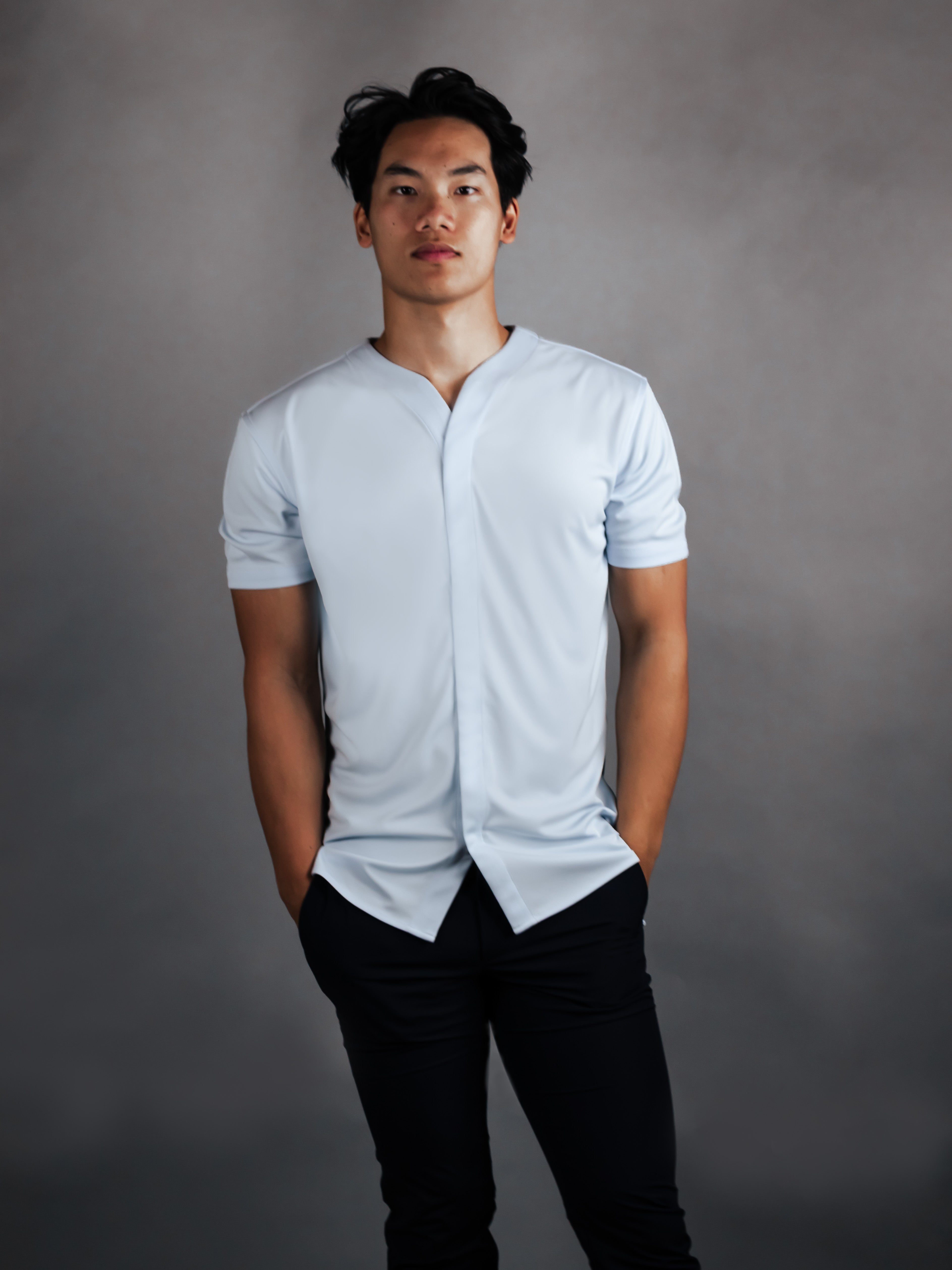 Model wearing tapered collarless dress shirt in short sleeve version.