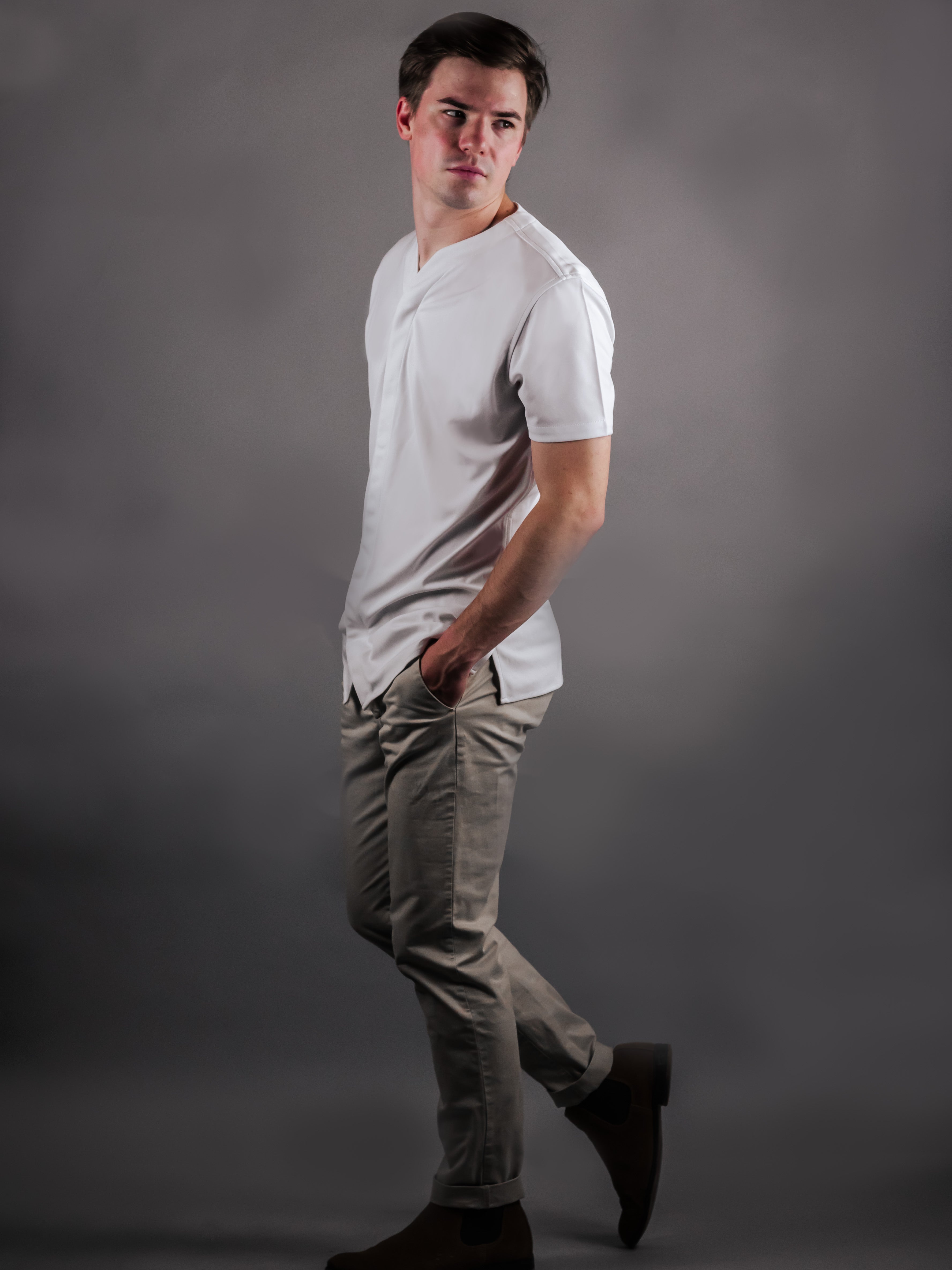 Muscular man wearing a collarless dress shirt with short sleeves in white