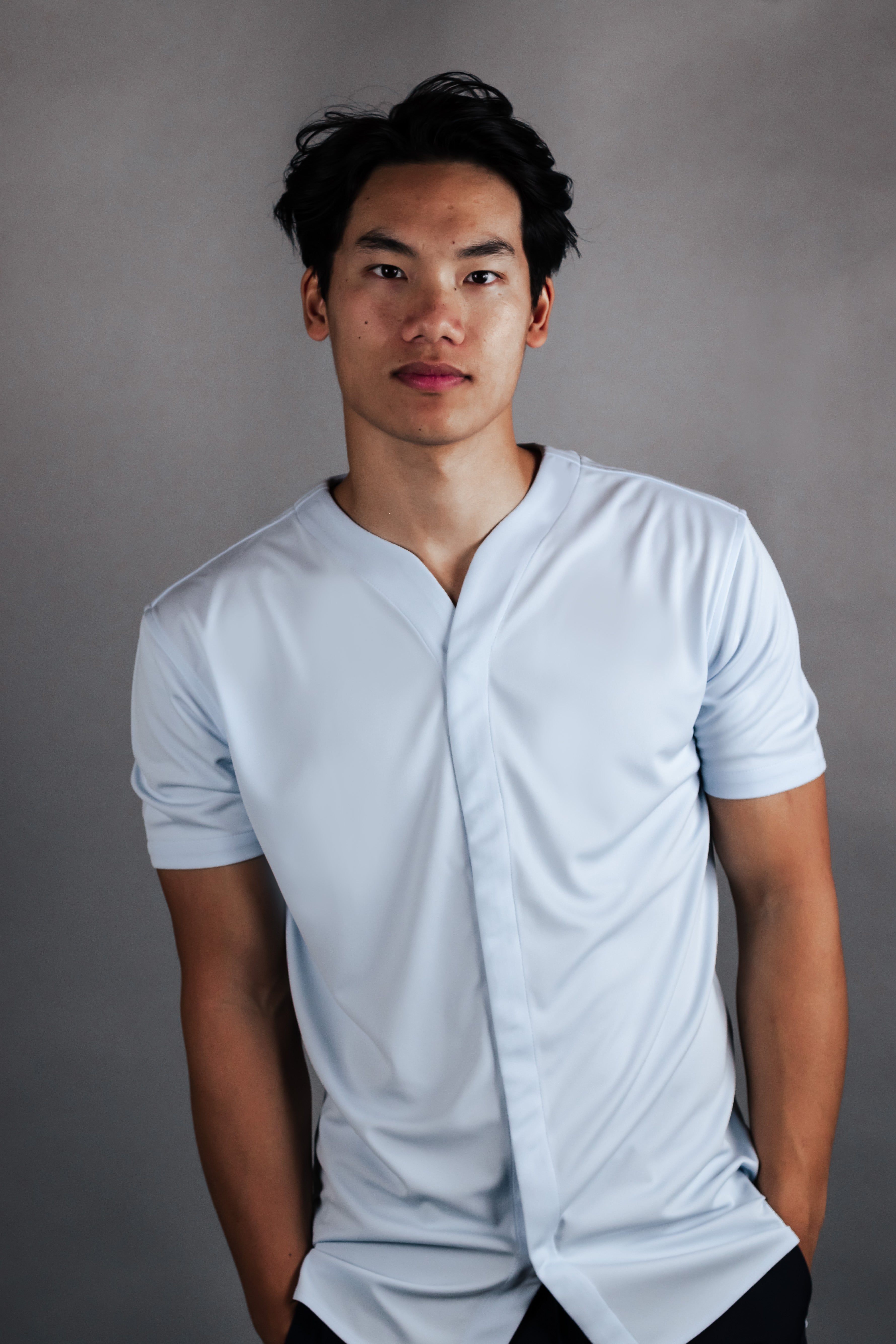 Young man wearing a collarless golf shirt in light blue made by Cheegs