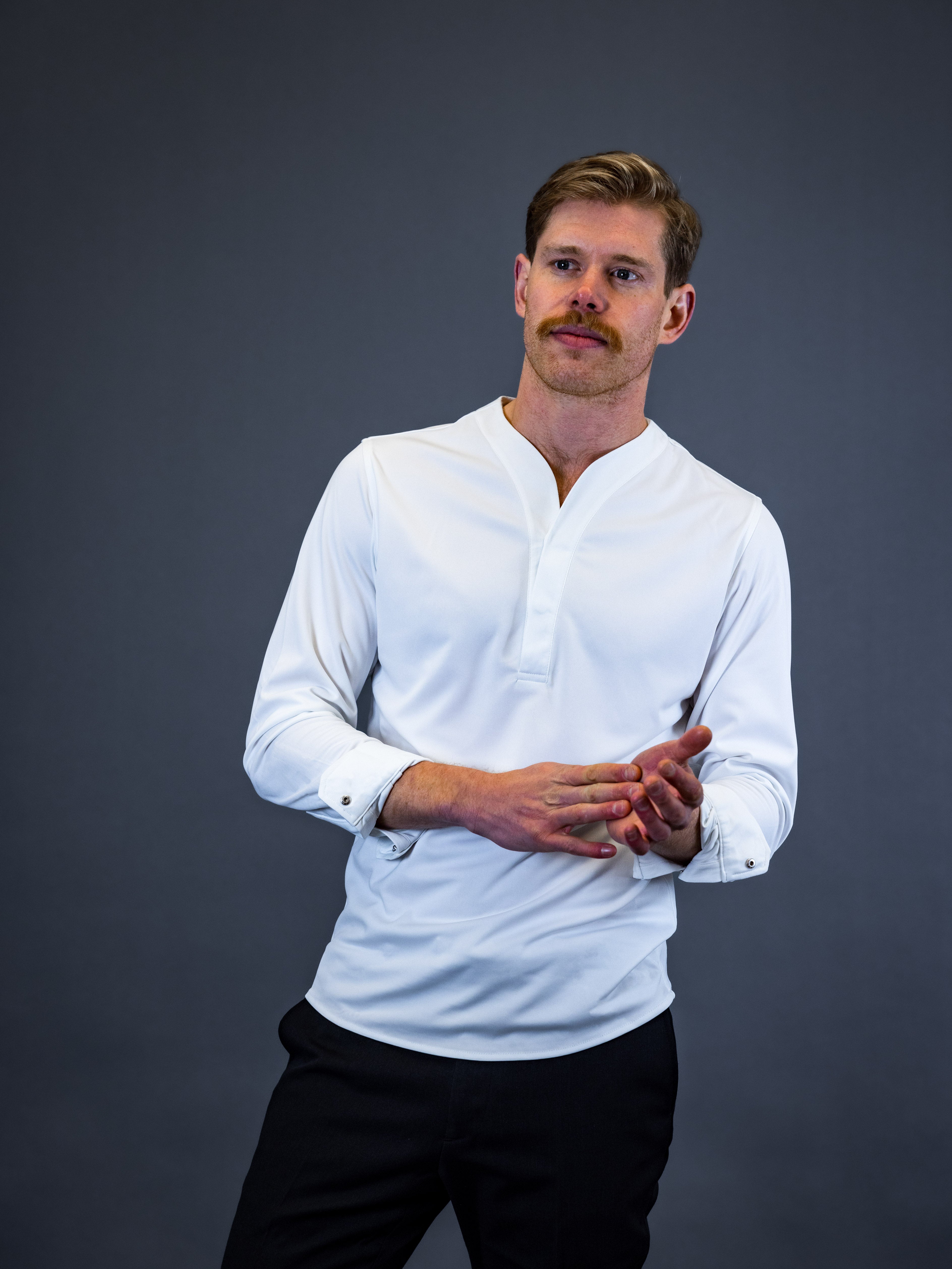 Model wearing a white men's collarless dress shirt made by Cheegs