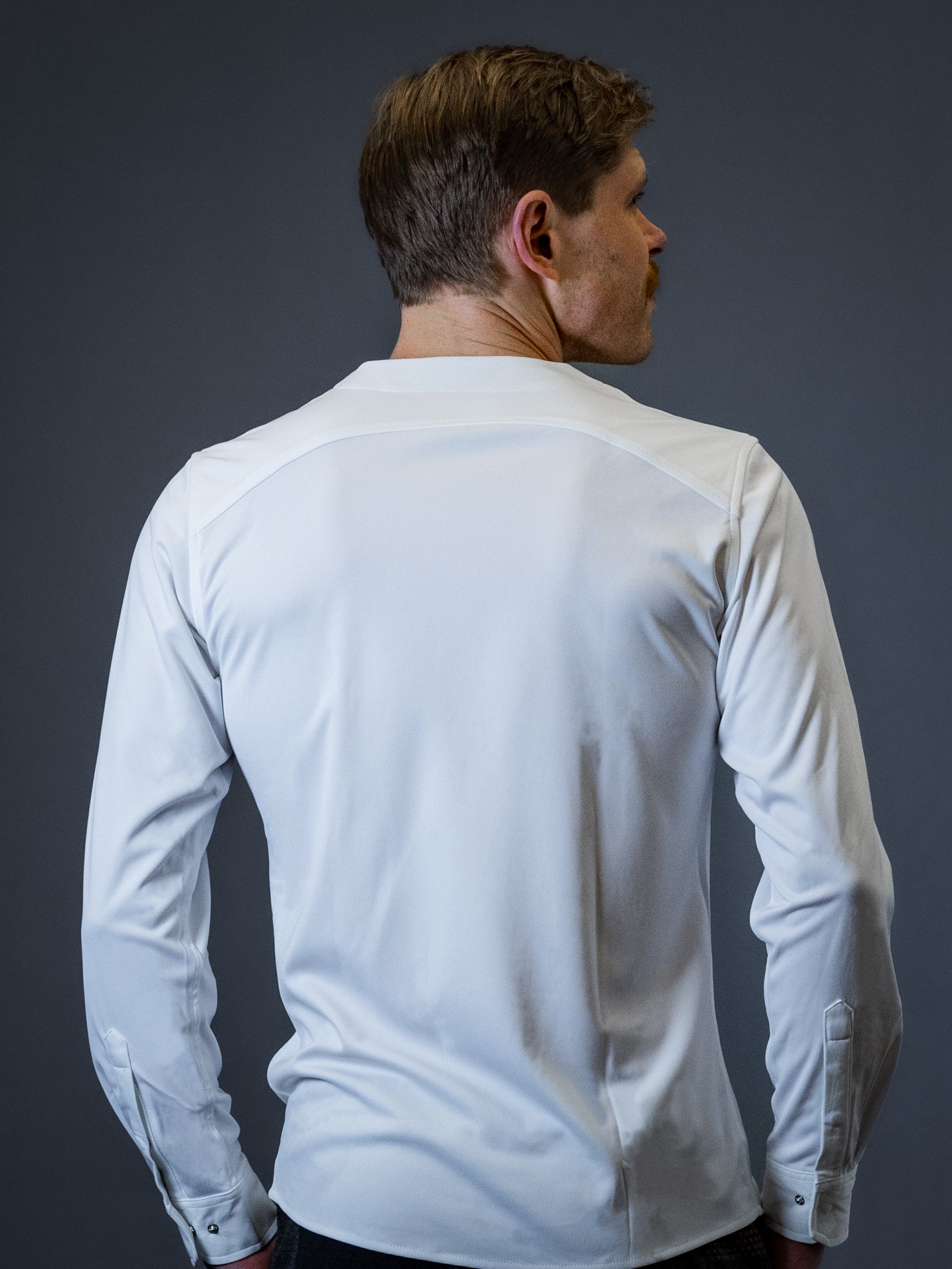 Man showing the back of a white collarless dress shirt made by Cheegs Shirts