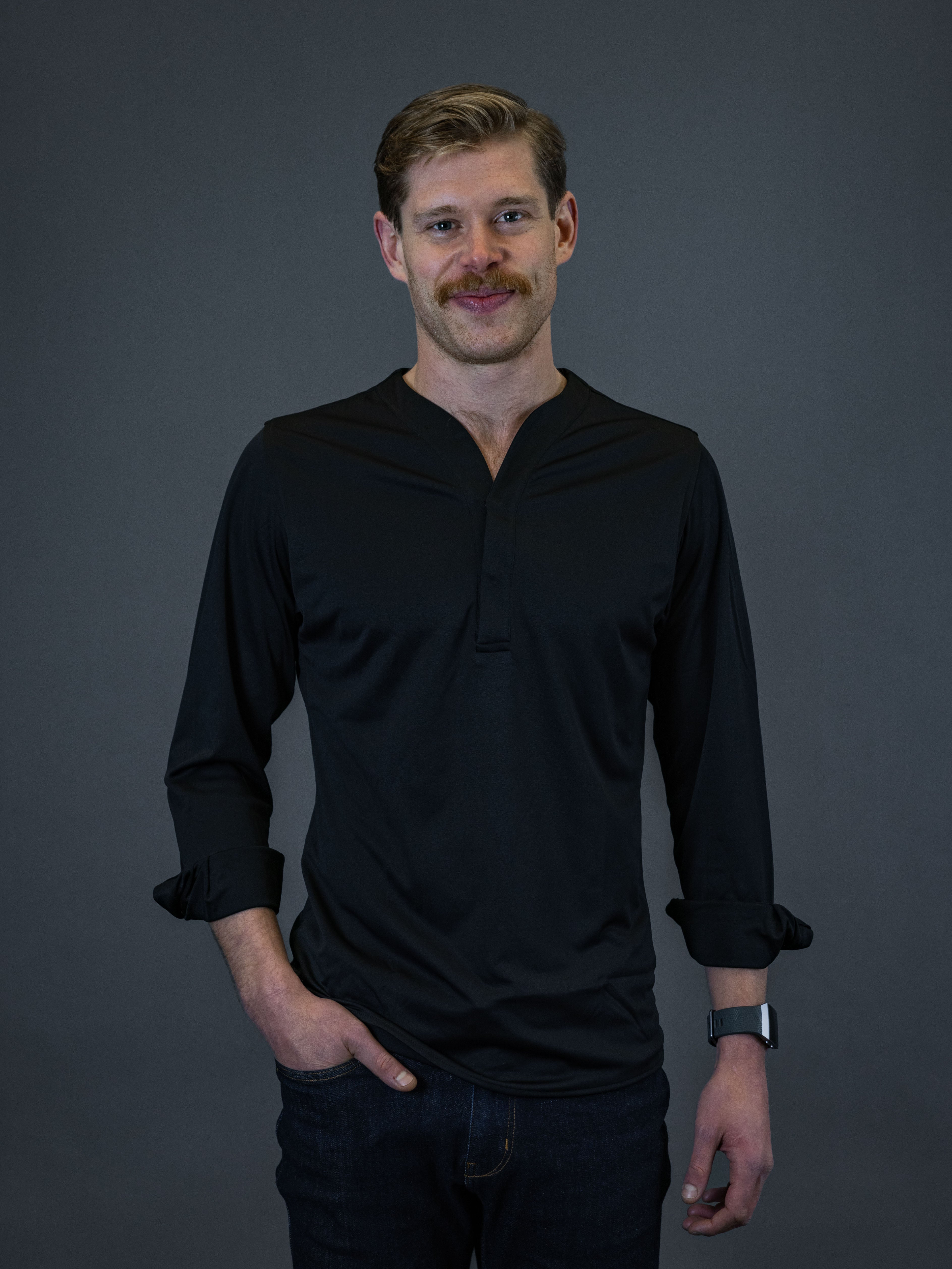 Young man with mustache wearing the cheegs hybrid popover which is part of their collection of casual dress shirts for men