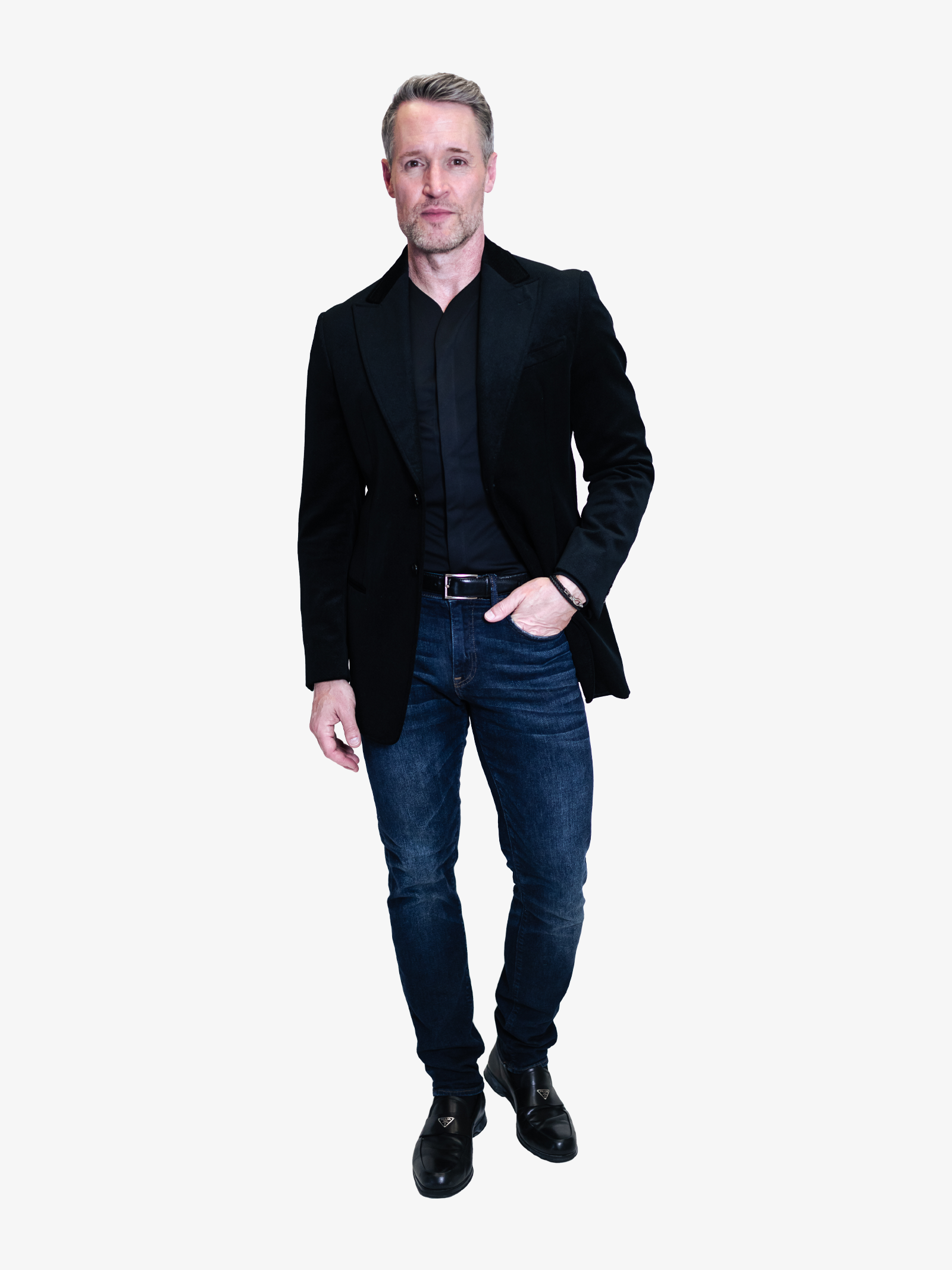 Man wearing a mens collarless dress shirt in black tucked in, with a nice pair of jeans and a dark sports coat. 